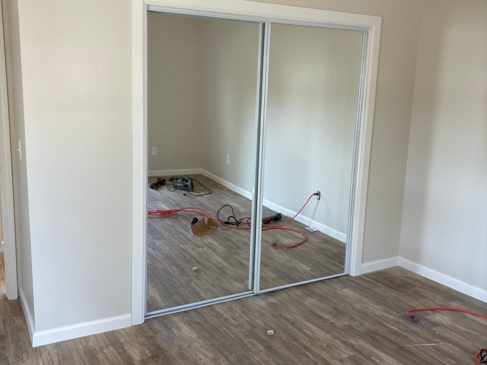 Finished mirrored sliding closet doors installed in the bedroom